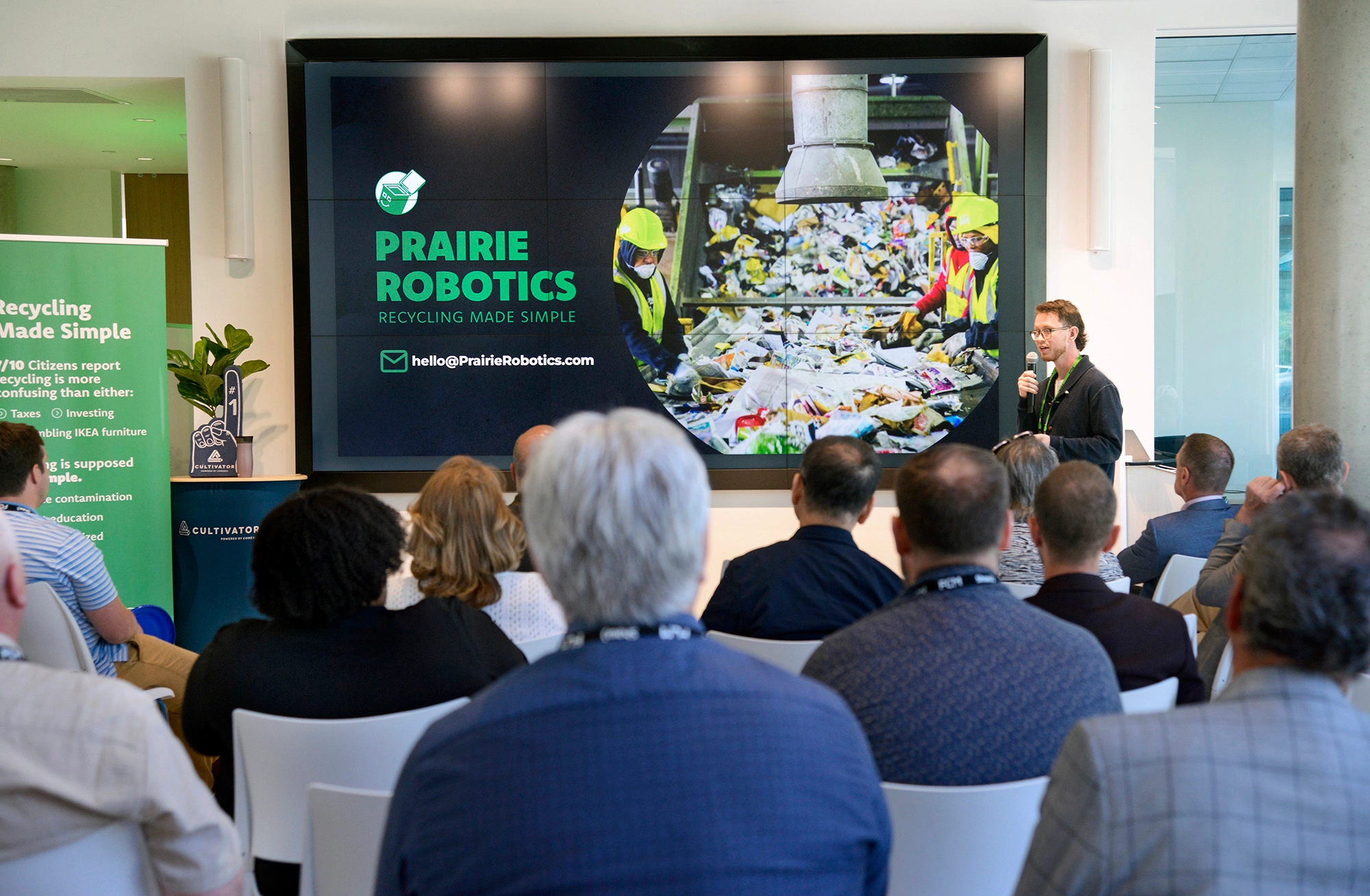 A Prairie Robotics presentation on a large screen in front of a seated conference audience