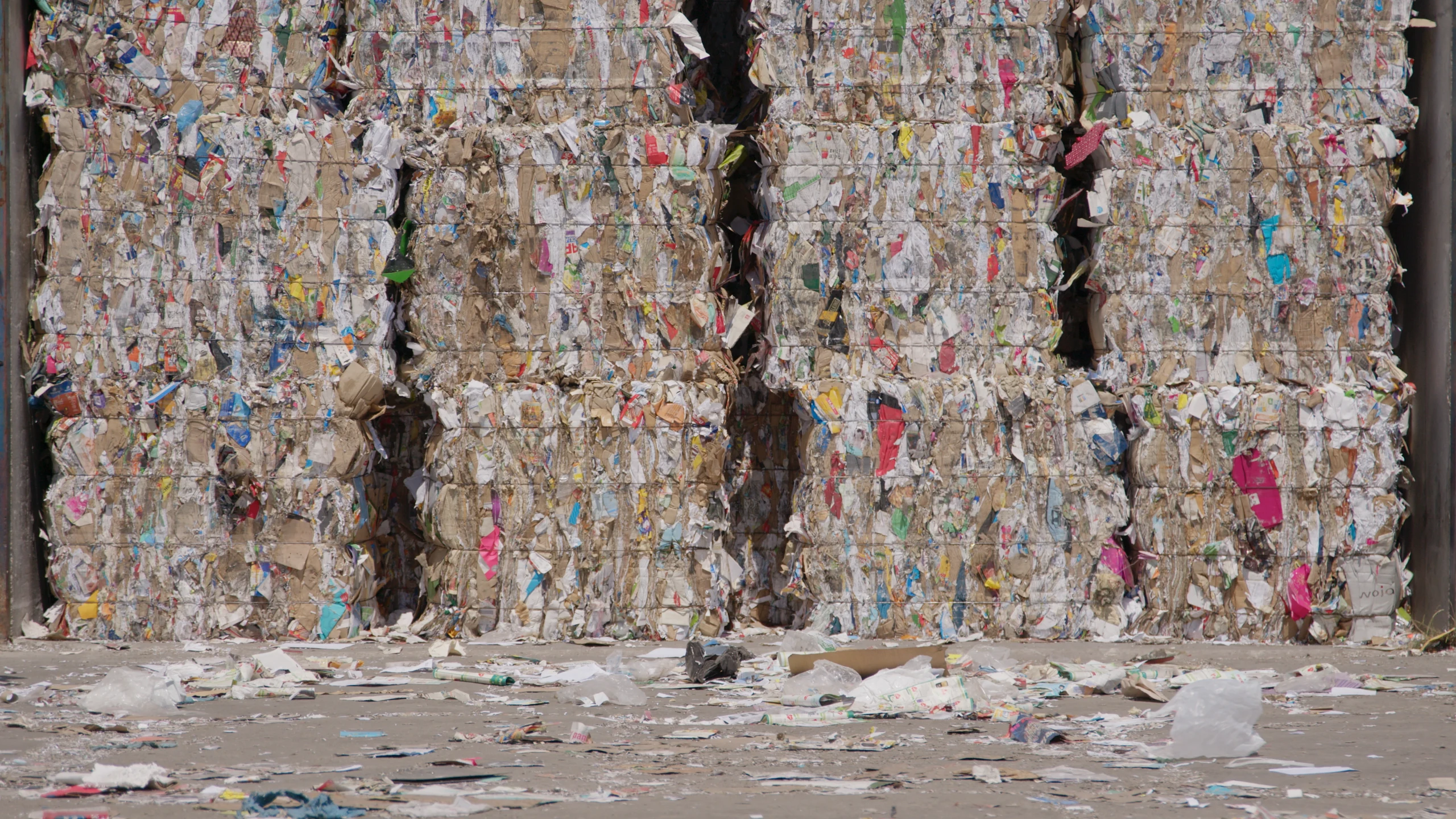Tall stacked bales of compressed mixed paper and plastic recyclables