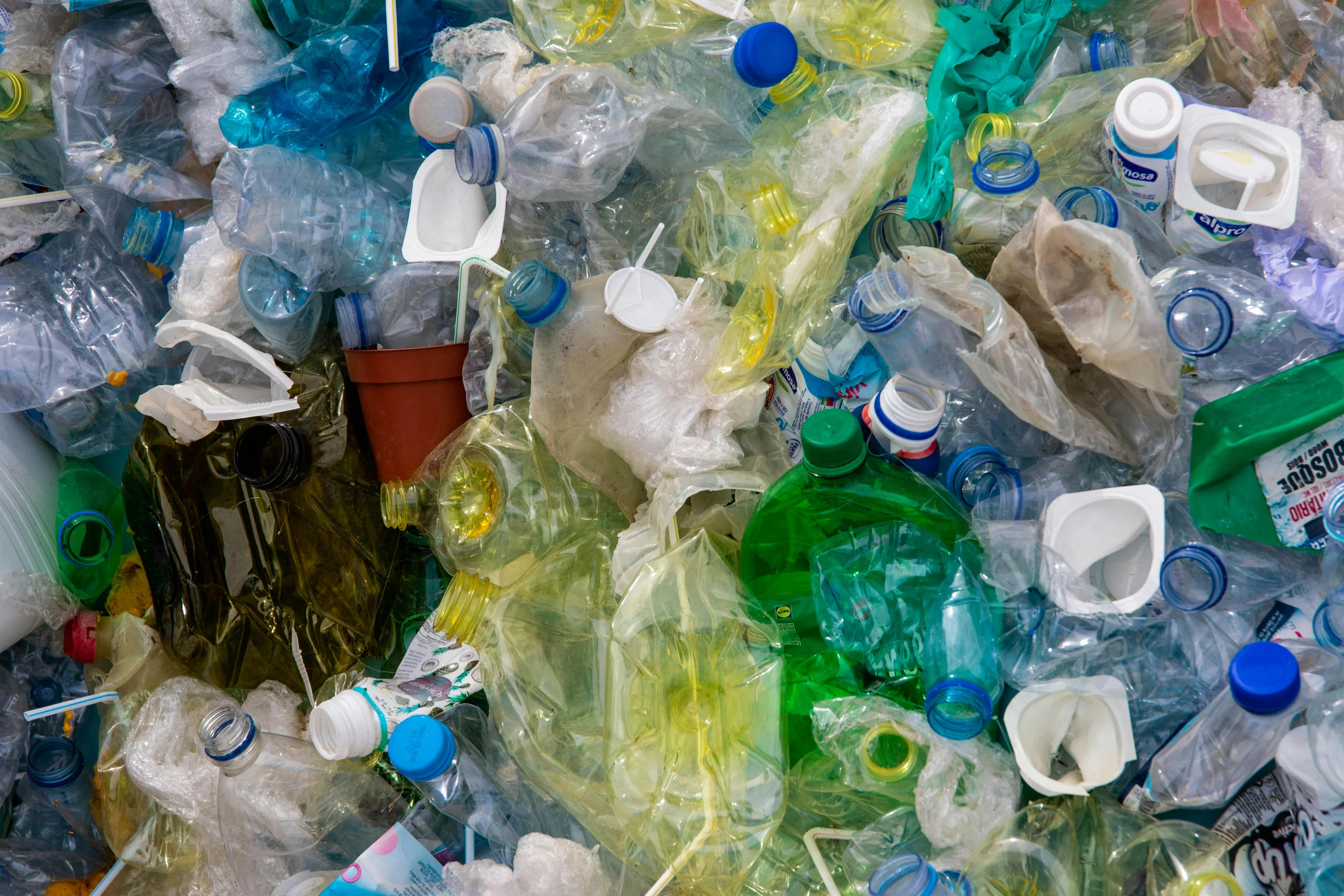 A pile of discarded plastic bottles, cups and packaging