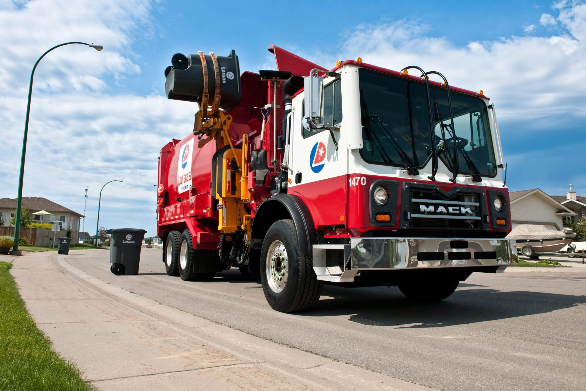 Red and white Loraas automated side-loader garbage truck on a residential street